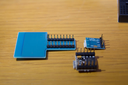 ピンヘッダを半田付けしたESP-WROOM-02 DIP化キットの裏面と、USBシリアル変換基板を木製の机に並べた様子